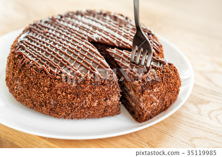 Sliced tasty chocolate cake served on wooden table Sliced tasty chocolate cake served on wooden table 35119985
