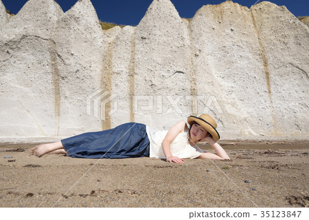 在北海道大部市，在沙灘上的牛仔裙上戴著草帽拍攝一名婦女的肖像 35123847