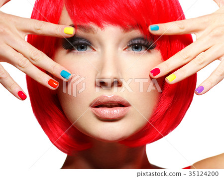 Closeup face of a beautiful  girl with  multicolor nails. 35124200