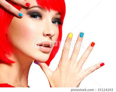 Closeup face of a beautiful  girl with  multicolor nails. 35124203