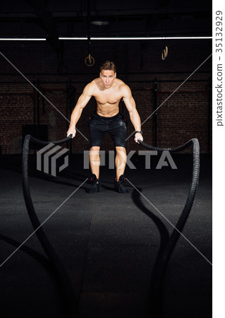 Fitness man workout with battle ropes at gym 35132929