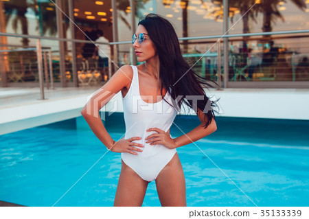 Sexy Woman standing near the pool in a white Sexy Woman standing near the pool in a white 35133339