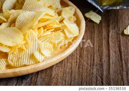 Snacks in a wooden dish on a table Snacks in a wooden dish on a table 35136530