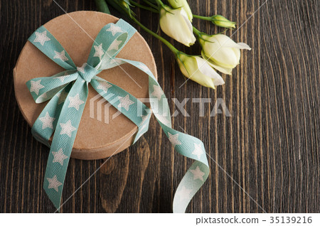Gift box with star ribbon on dark rustic table Gift box with star ribbon on dark rustic table 35139216