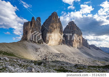 Tre Cime di Lavaredo against cloudy blue sky Tre Cime di Lavaredo against cloudy blue sky 35142835