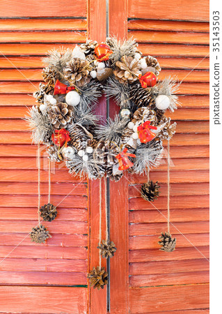 Christmas wreath hanging on wooden blinds 35143503