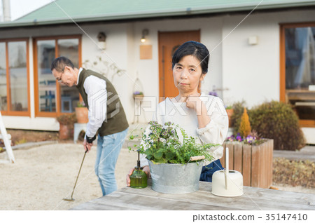Senior couple relaxing in the garden Senior couple relaxing in the garden 35147410