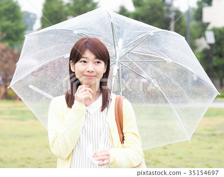 拿著一把傘的婦女在公園 拿著一把傘的婦女在公園 35154697