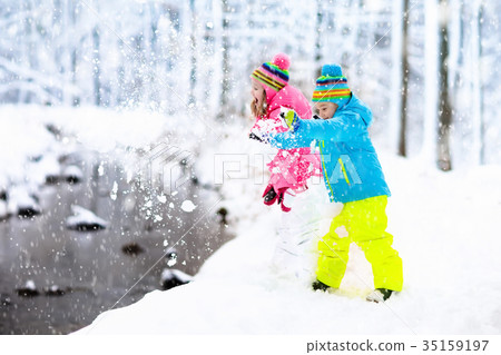 Kids playing in snow. Children play in snowfall. 35159197