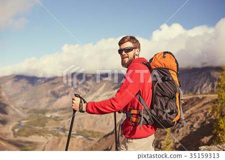 Handsome young bearded male hiker standing on the 35159313