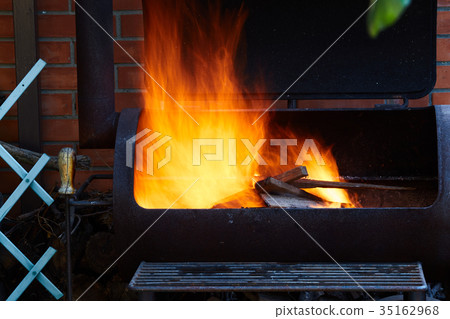Burning firewood in the barbecue at backyard close 35162968