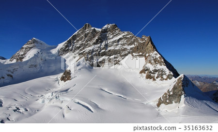 Peak of mount Jungfrau and glacier with crevasses. Peak of mount Jungfrau and glacier with crevasses. 35163632