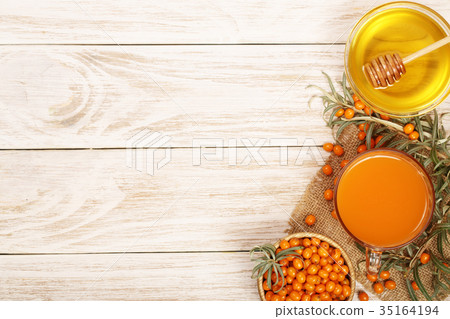 Sea buckthorn juice or tea with honey on a white 35164194