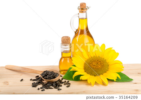 Sunflower oil, seeds and flower on wooden table 35164209