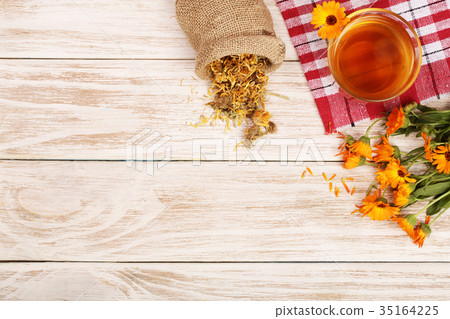 Calendula tea with fresh and dried flowers on Calendula tea with fresh and dried flowers on 35164225
