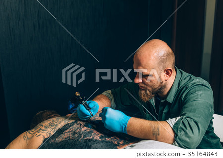 tattoo master artist makes a tattoo. Closeup 35164843