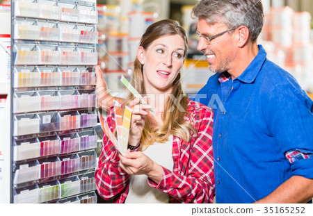 Couple choosing color of paint in hardware store Couple choosing color of paint in hardware store 35165252