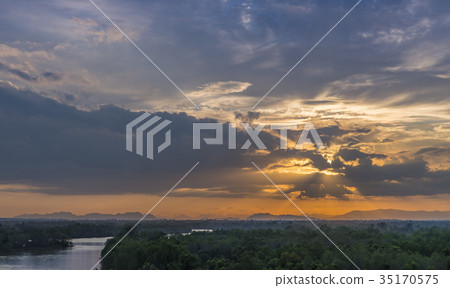 Sunset with light beam over forest and river 35170575