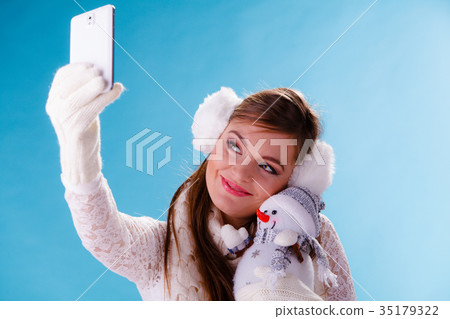 Woman with little snowman taking selfie photo. Woman with little snowman taking selfie photo. 35179322
