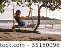 Woman on swings at the seashore 35180096