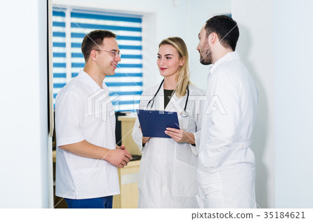 Group of doctors discussing and working together Group of doctors discussing and working together 35184621