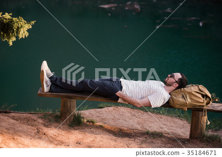 Man Relaxing Outside. Wearing a white T shirt Man Relaxing Outside. Wearing a white T shirt 35184671
