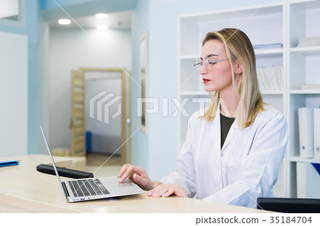 Smiling nurse with laptop scheduling appointment Smiling nurse with laptop scheduling appointment 35184704