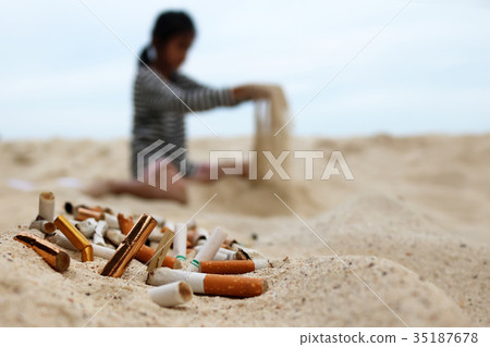 Cigarette and tobacco ashtray on the beach 35187678