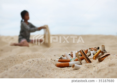 Cigarette and tobacco ashtray on the beach Cigarette and tobacco ashtray on the beach 35187680