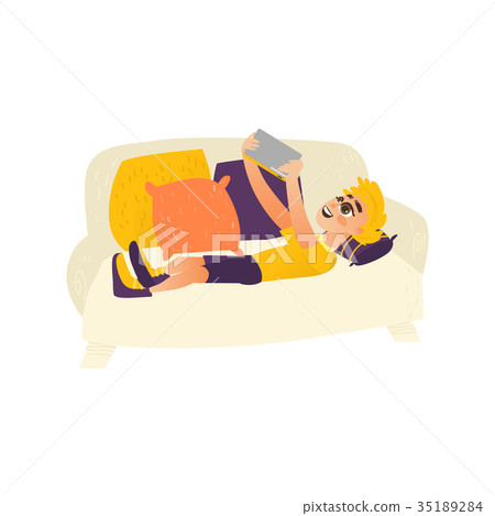 Teenage boy lying on sofa, using tablet gadget Teenage boy lying on sofa, using tablet gadget 35189284