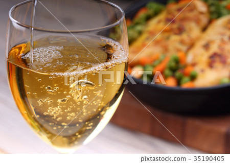 Pouring white wine into glass Pouring white wine into glass 35190405