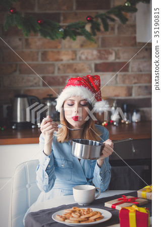 woman sitting at kitchen with pan and spoon 35190815