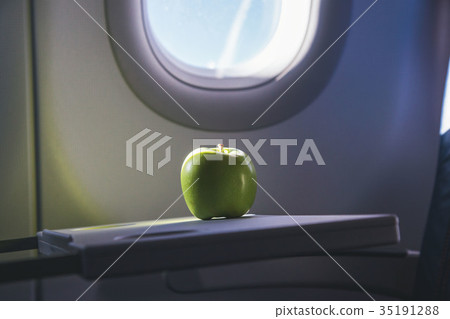 a green apple on the table of airplane a green apple on the table of airplane 35191288