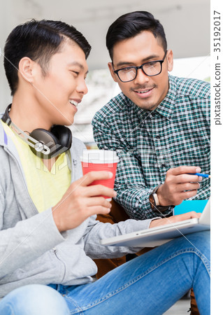 Experienced employee explaining to his colleague Experienced employee explaining to his colleague 35192017