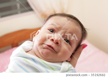 Woman holding a sweet hispanic newborn crying 35192682