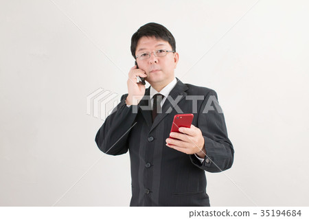 與智能手機和車庫的一個商人，一個中年人 35194684