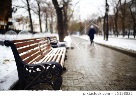 bench in a cold winter park snow 35198825