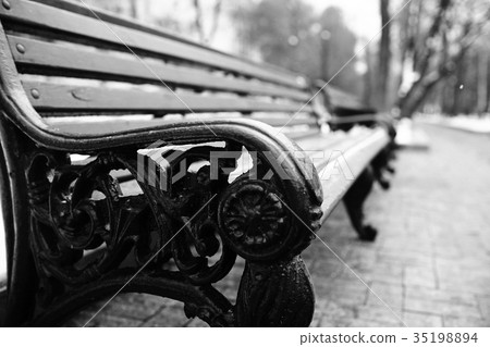 bench in a cold winter park snow 35198894