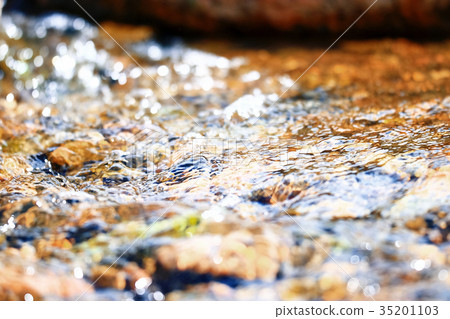 Multi-colored pebbles in a stream 35201103