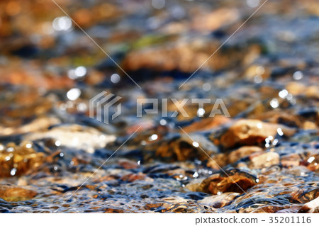 Multi-colored pebbles in a stream 35201116