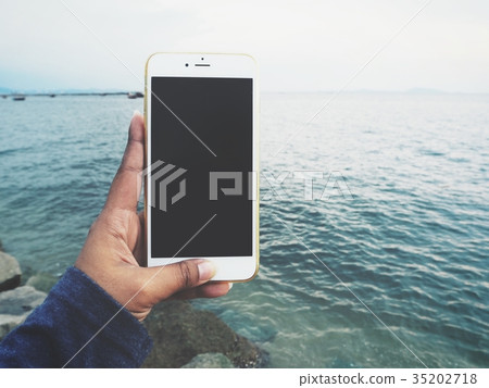 Woman using smart phone on the beach 35202718