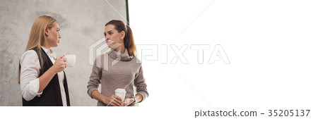 Two young girlfriend sitting in modern coffee shop Two young girlfriend sitting in modern coffee shop 35205137