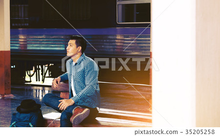 asian hipster young man sitting at train station asian hipster young man sitting at train station 35205258