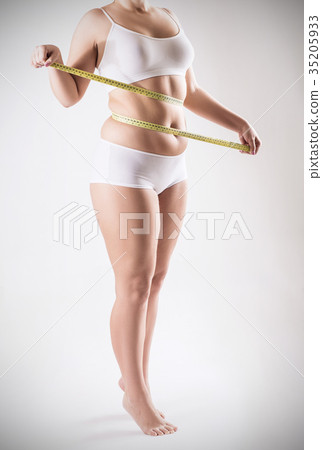 Overweight woman measuring her fat belly. 35205933
