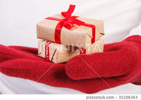 Hand of woman in gloves with gifts for Christmas 35206363