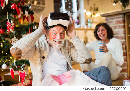 Senior couple in front of Christmas tree with VR Senior couple in front of Christmas tree with VR 35206901