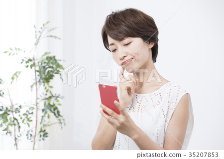 A woman watching a smartphone A woman watching a smartphone 35207853