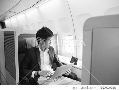 Asian businessman using laptop on first class cabi 35208950
