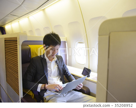 Asian businessman using laptop on first class airp Asian businessman using laptop on first class airp 35208952