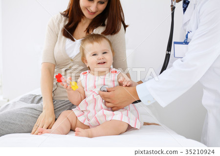 Happy cute baby with her mother at health exam at Happy cute baby with her mother at health exam at 35210924
